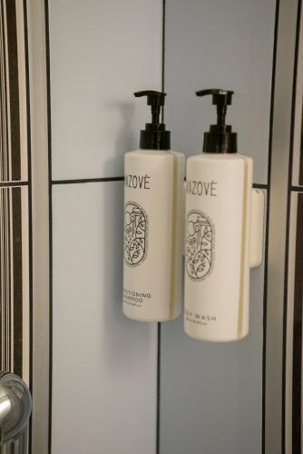 two bottles oflove on a wall in a bathroom at Ioannina Amazing Deluxe Apartment in Pedini