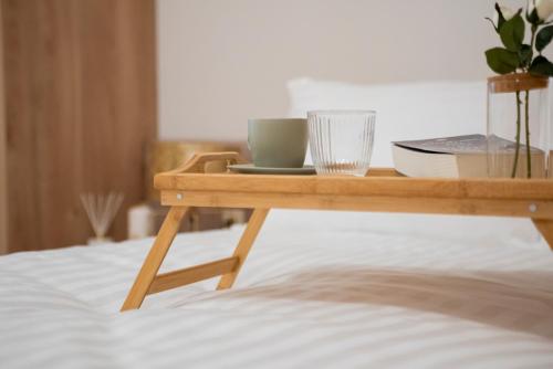 a wooden tray with a cup on a bed at Ioannina Amazing Deluxe Apartment in Pedini