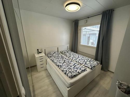 niewielka sypialnia z łóżkiem i oknem w obiekcie Bright house for short stay w mieście Vantaa