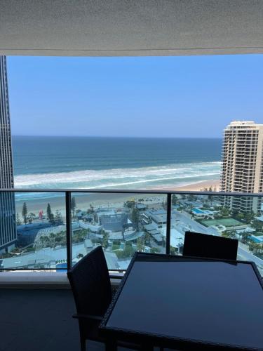 a table and chairs in a room with a view of the ocean at H Luxury Apartment at Surfers Paradise High floor in Gold Coast