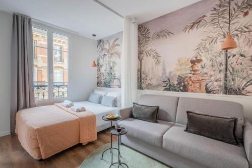 a living room with a couch and a bed at Résidence Le Belleville in Paris