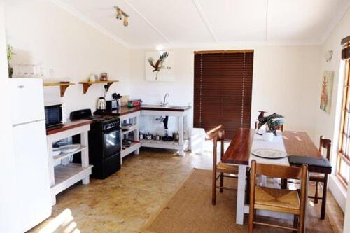 a kitchen with a table and a dining room at Crane Cottage in Nottingham Road