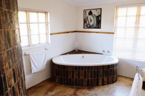 a bathroom with a large tub in the corner at Crane Cottage in Nottingham Road