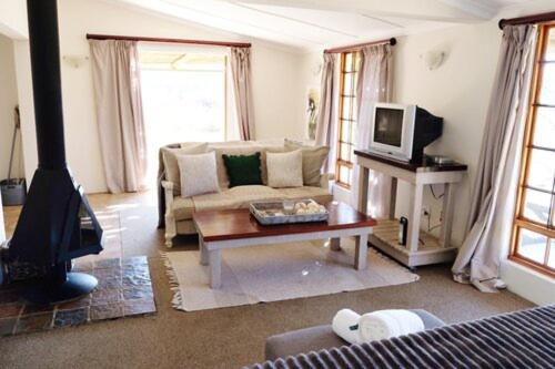 a living room with a couch and a fireplace at Crane Cottage in Nottingham Road