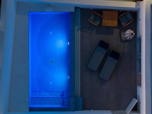 a blue shower in a room with a wall at Aegean Melody Suites & Villas in Vlychada