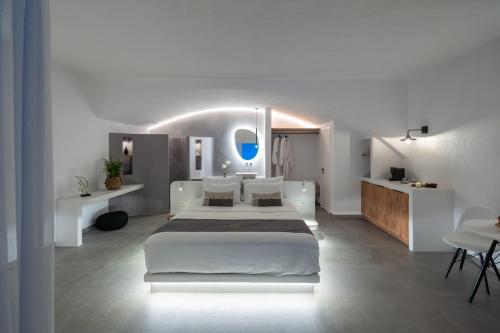 a white bedroom with a large bed in it at Aegean Melody Suites & Villas in Vlychada