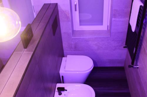 a purple bathroom with a toilet and a sink at La Dimora Del RE in Salerno