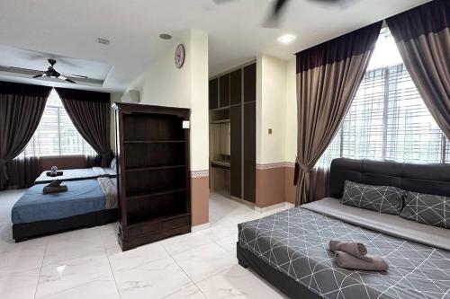 a bedroom with a bed and a couch and windows at 21pax KL Event Bungalow in Ampang