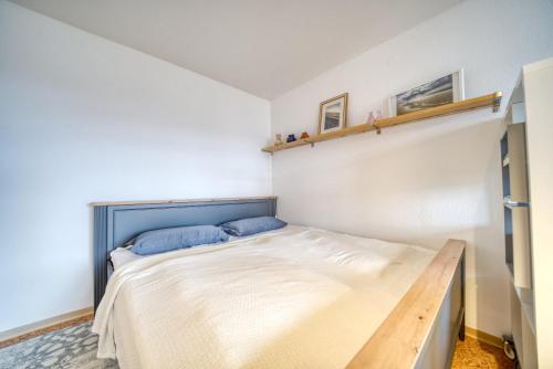 una camera da letto con un grande letto con cuscini blu di Ferienpark - Haus C, App 0C0512 a Heiligenhafen