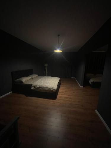 a dark room with a bed and a light at Hotel sofra in Ferizaj