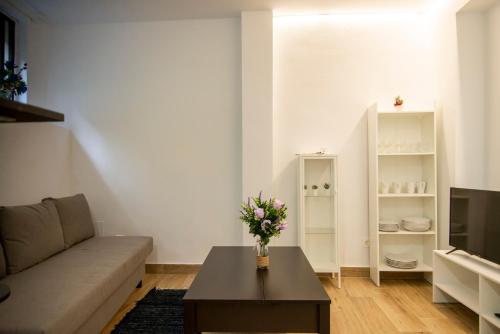 uma sala de estar com um sofá e uma mesa com flores em Bilbao centro Zumaia2 em Bilbao
