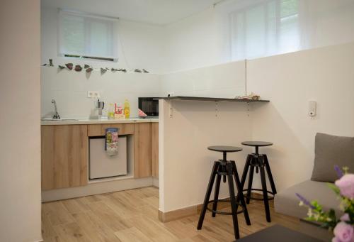 a kitchen with two bar stools in a room at Bilbao centro Zumaia2 in Bilbao