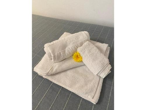 een stapel handdoeken met een gele bloem erop bij Complejo Colibri 13 in Cambrils