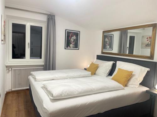 a bedroom with two beds and a mirror on the wall at Komfort-Apartments Waidring in Waidring