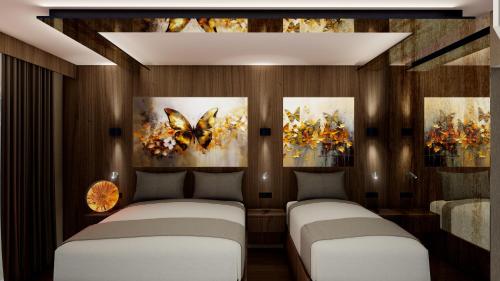 two beds in a room with paintings on the wall at duqqan deluxe hotel in Kuşadası