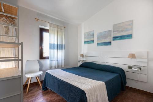 a bedroom with a bed and a chair in it at Residence il Melograno in San Teodoro