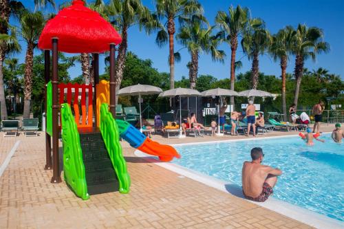 a group of people playing in the swimming pool at a resort at Don Antonio Glamping Village in Giulianova