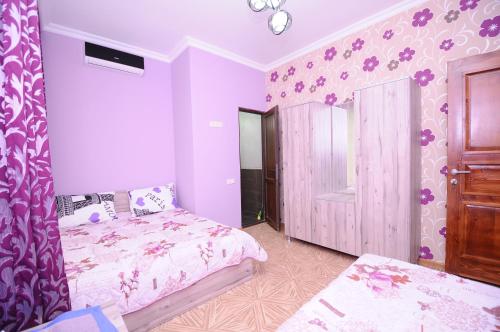 a bedroom with a bed and a purple wall at Guest House Giorgi in Makhinjauri