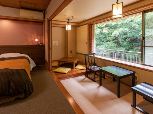 een kamer met een bed en een groot raam bij Shima Yamaguchikan in Nakanojo