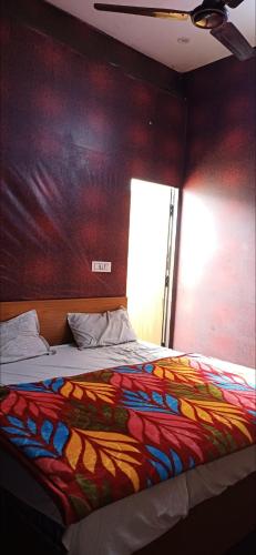 um quarto com uma cama colorida e uma parede em Hotel green em Faridabad