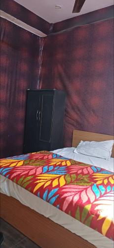 a bed with a colorful comforter in a room at Hotel green in Faridabad