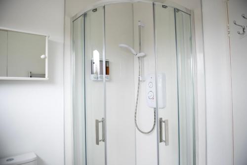 um chuveiro com uma porta de vidro na casa de banho em Tillyard Retreat, Ground Floor Apartment Cambridge em Cherry Hinton
