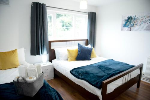 um quarto com 2 camas e uma janela em Tillyard Retreat, Ground Floor Apartment Cambridge em Cherry Hinton