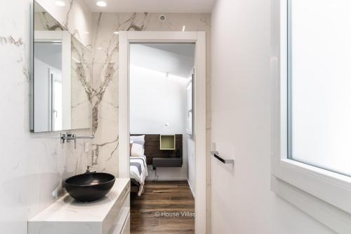 La salle de bains est pourvue d'un lavabo noir et d'un miroir. dans l'établissement FlaBen Luxury Villa, à Avola