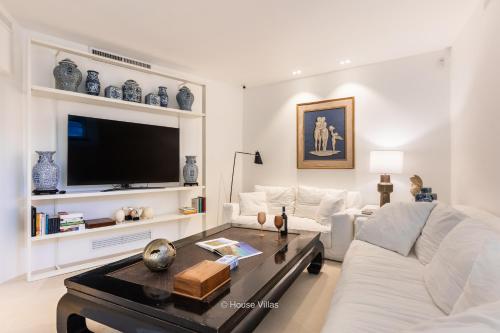 sala de estar con sofá blanco y TV en Villa DeMar, en Plemmirio