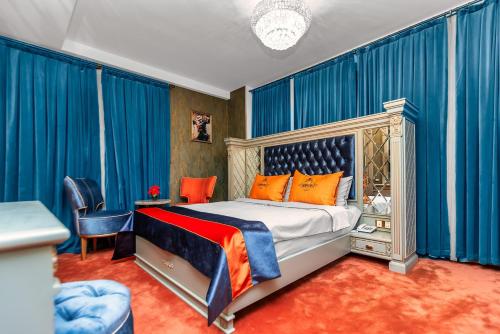 バクーにあるManor Luxury Hotel Bakuのベッドルーム(青いカーテン付きのベッド1台付)