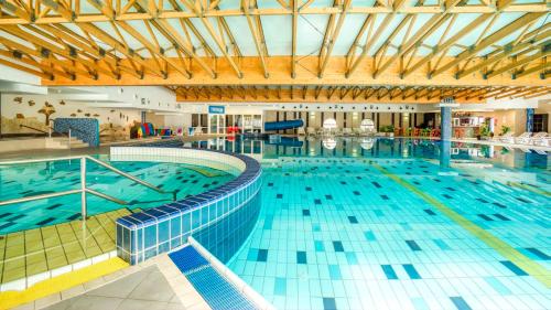 a large swimming pool in a large building at Villa Green in Sliač