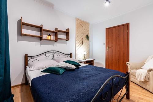sypialnia z łóżkiem z niebieską kołdrą w obiekcie Aparteo Apartament Brzegi w Zakopanem