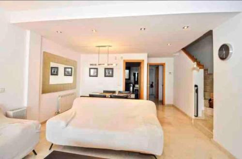 a large living room with a large white bed at Wonderful townhouse on Sa Boadella beach in Lloret de Mar