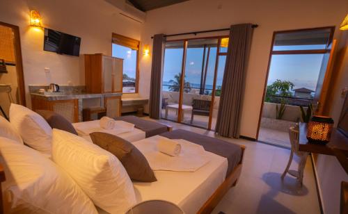 a living room with a bed and a large window at Hotel Bay Watch Unawatuna in Unawatuna