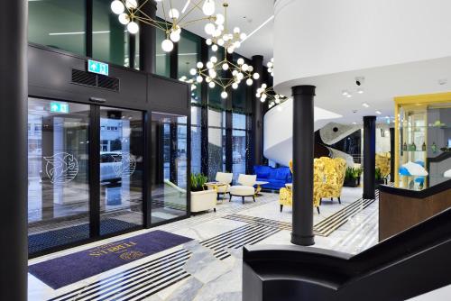 a lobby of a store with yellow chairs and tables at Hotel Ferreus Modern Art Deco in Kraków