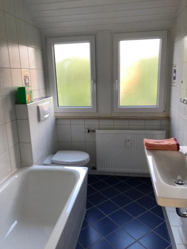 een badkamer met een bad, een toilet en een wastafel bij Grüne Oase in Bad Nenndorf