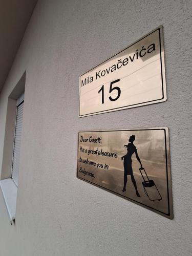 a sign on a wall with a person with a suitcase at Expo Airport otel in Surčin