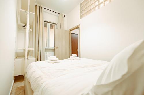 a bedroom with a white bed with towels on it at Loft Pozzo Strada in Turin