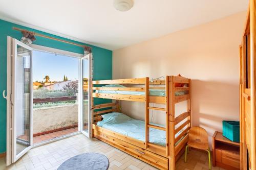 Cette chambre dispose de lits superposés et d'une porte donnant sur un balcon. dans l'établissement Céleste - Maison 3 chambres et jardin, au Pradet