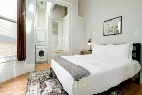 a white bedroom with a large bed and a window at Missions Dolores 1br nr dining cafes shops SFO-1621 in San Francisco