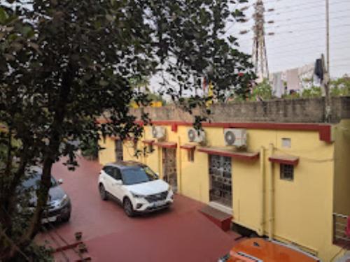 une voiture blanche garée devant un bâtiment dans l'établissement Shanti Guest House,Bhubaneswar, à Bhubaneswar