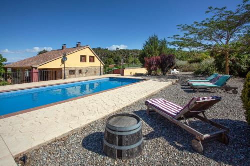 a swimming pool with a chair and a barrel next to it at Aaccent Montblanc - Prenafeta in Montblanc