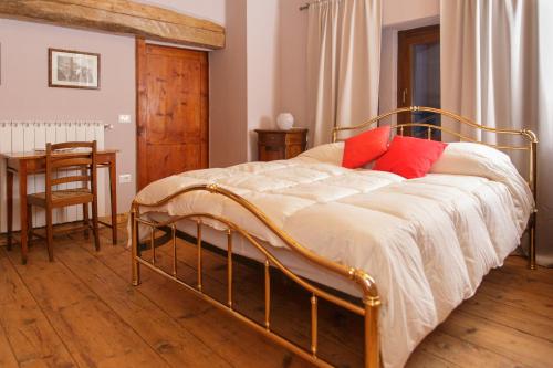a bedroom with a bed with red pillows on it at Casa Pini Rio_A in Riolunato