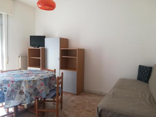 Zimmer mit einem Tisch, einem Bett und einem TV in der Unterkunft Residence Villa Carmen fronte mare a 50 mt in Pietra Ligure
