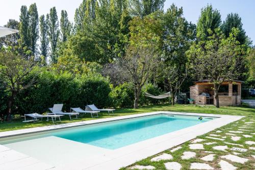 カザーレ・スル・シーレにあるLa Meridiana B&Bの椅子と木々のある庭のスイミングプール