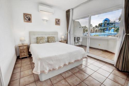 - une chambre avec un lit blanc et une grande fenêtre dans l'établissement Luxury Apartment in BenalBeach with Water Park, à Benalmadena Costa