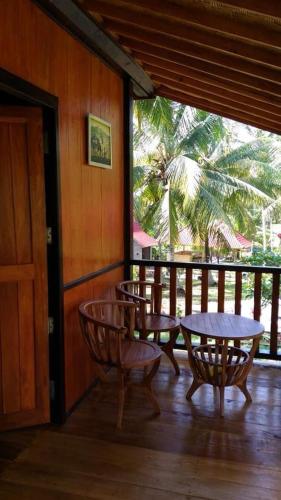 a patio with a table and chairs on a porch at Pondok Jati Mulo Jembrana in Jembrana