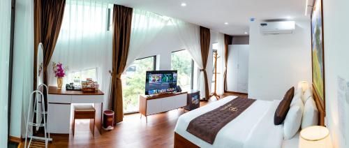 a bedroom with a bed and a desk and a television at Big Hotel Lào Cai in Lao Cai