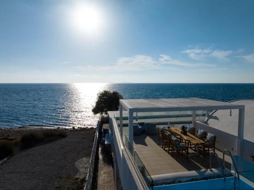 a view of the ocean from the balcony of a house at Aegean Melody Suites & Villas in Vlychada