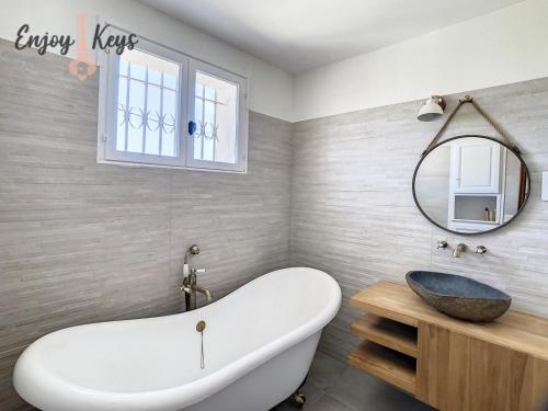 y baño con bañera blanca y espejo. en Magnifique Villa Provençale en Mallemort